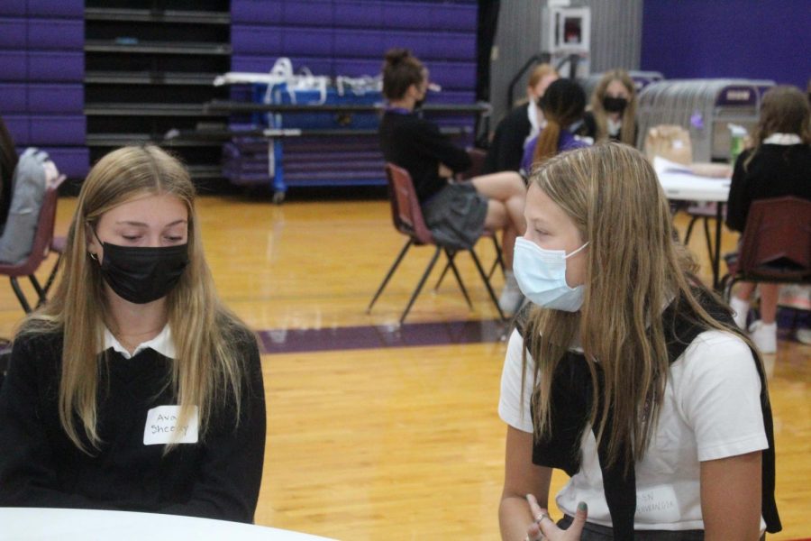 Senior Lauren Ellwanger and freshman Ava Sheedy chat during ice breaker activities at freshman orientation on Aug. 20.