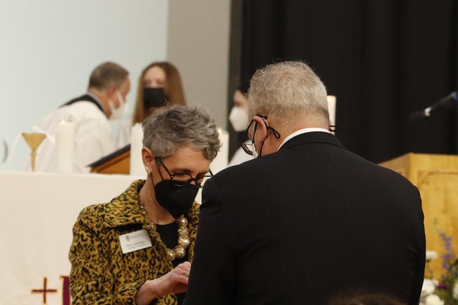 Principal of Academics Ellen Carmody gives communion to a guest.