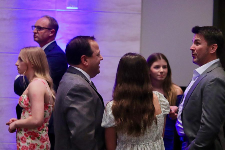 Dads and daughters greet one another in the event room.