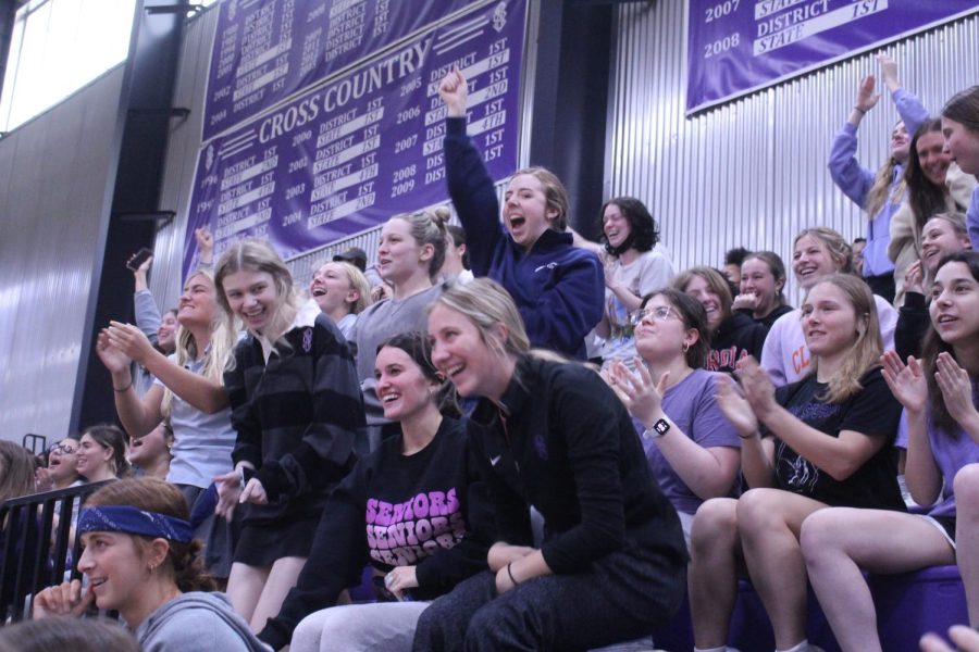 The senior class leaps up from their seats to cheer on their classmates.