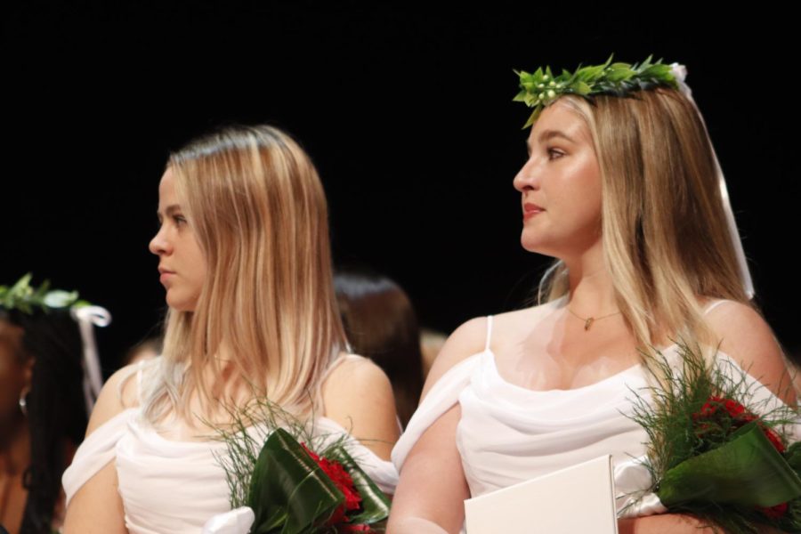 Maddie Haukap '22 and Liesl Riffe '22 listen to principal Natalie McDonough read names. 