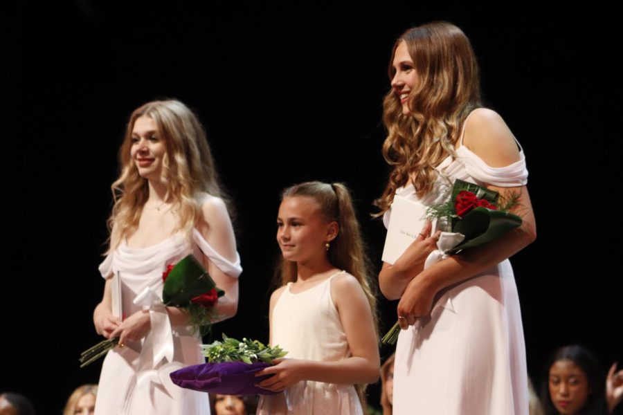 Addi Diaz '22 and Avery Marsden '22 stand with their crown bearer after receiving their diplomas. 