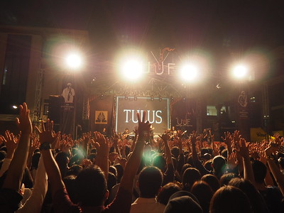 Concert goers in the pit share in a human experience while listening to their favorite artist. 