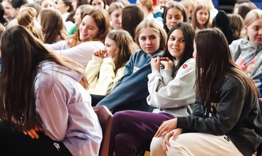 Freshmen Siobhan O'Connor and Addison Warn, smile as they participate in the prayer service discussion talking about their own religious experiences.