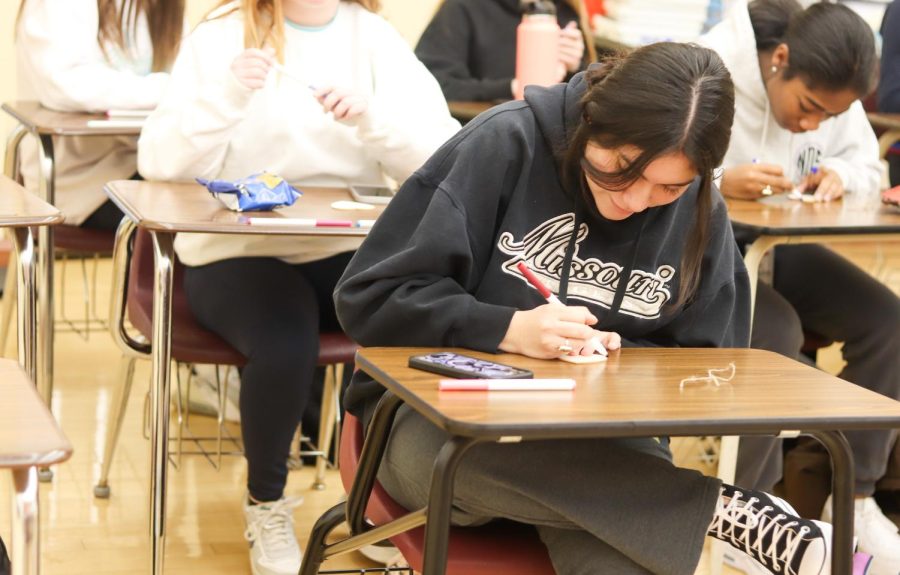 Senior Katherine Pineda fills in her heart as part of Thursday's Maison activity after the prayer service.