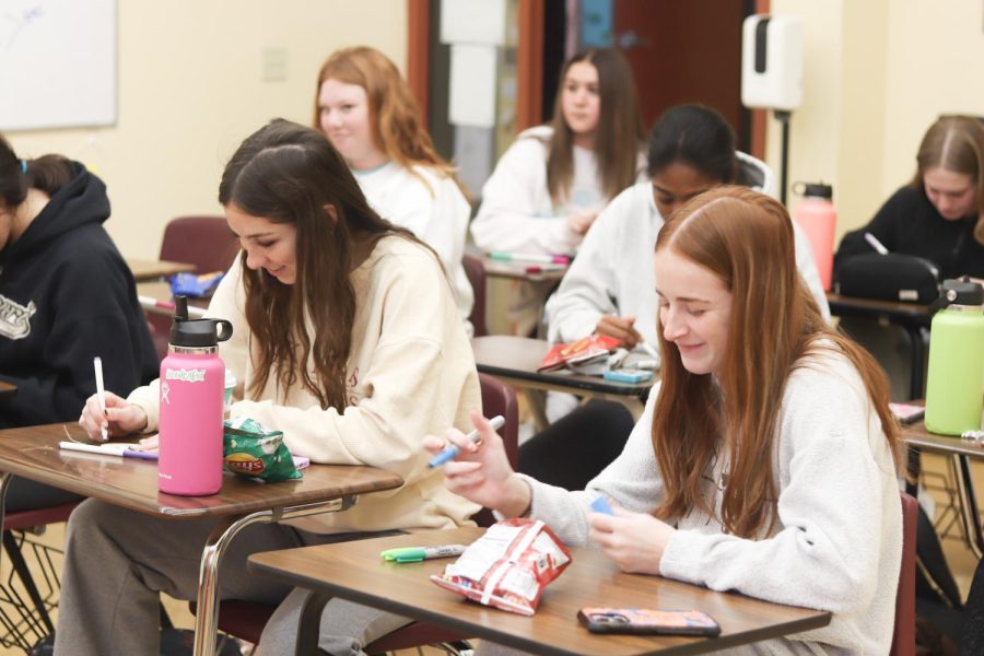 Sophomore Stella McClure and Junior Livvy Cavaliere enjoy the peaceful maison time as they fill in their wooden hearts.