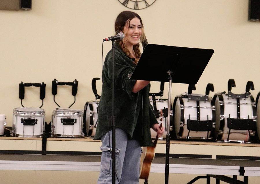 Senior Carolina O'Byrne collects her music from the stand after singing and playing ukulele to "Will You Still Love Me Tomorrow" by Carole King.