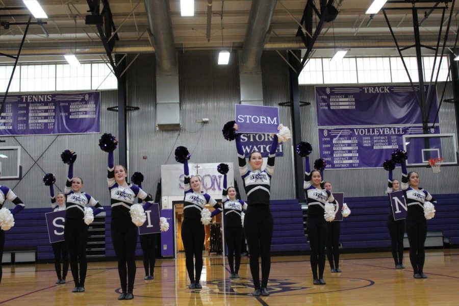 The Sion Dance team holds up their pom poms and signs as they wait to begin their performance.