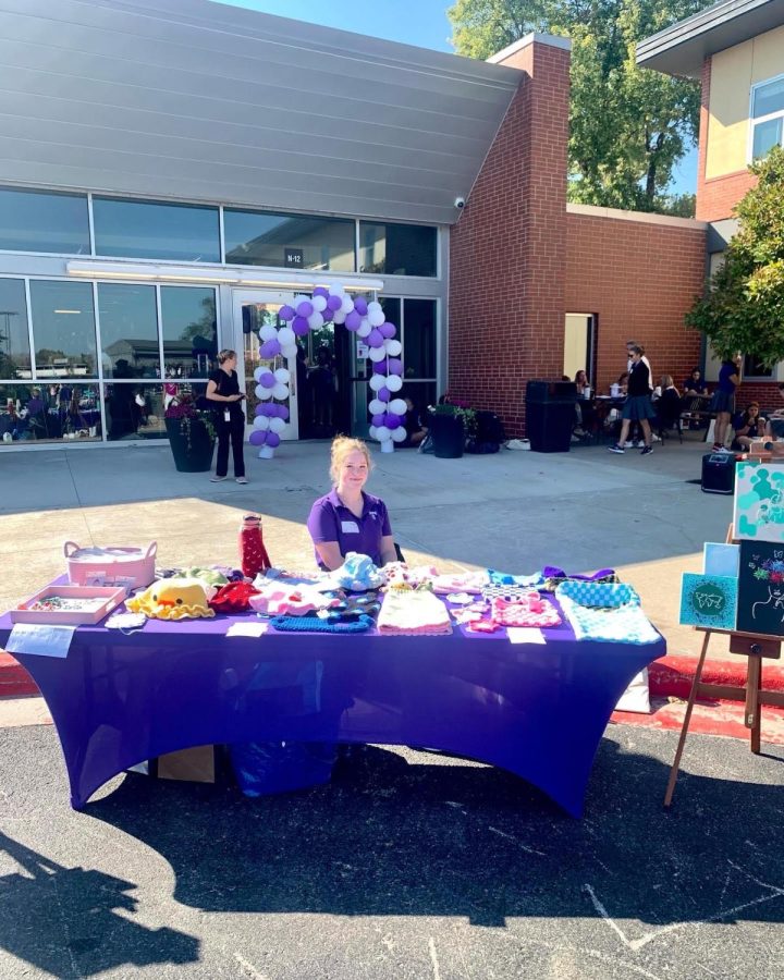 At the Sion marketplace, junior Gracie Orf, sits behind a table filled with crocheted hats, clay jewelry with custom paintings lining the outskirts of the table. 