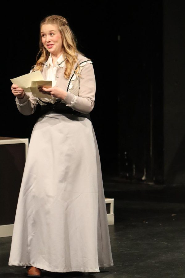 Beaming with pride, senior Addie Hiestand, playing Jo March, reads a telegram aloud.