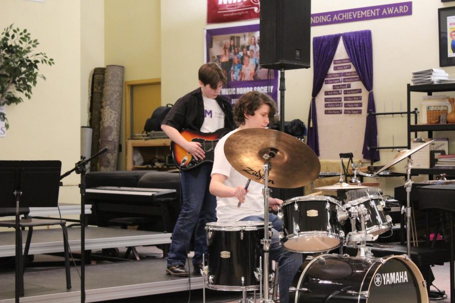 Sophomore Mel Laubscher plays guitar while freshman Meredith Daly plays the drums to "2000 Pound Bee" by Ventures. 