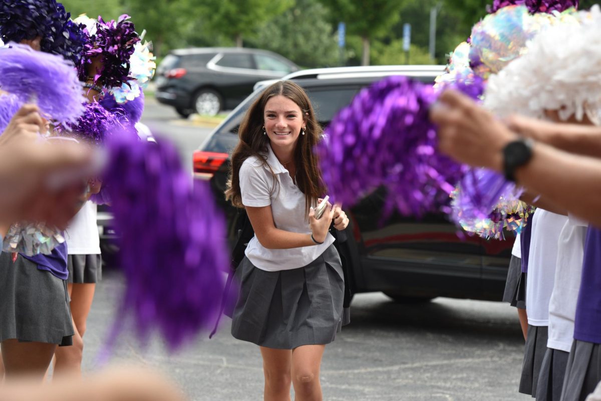 Striding towards the school, freshman Ava Doyle arrives at Sion on her first full day on August 22. The purple carpet is a yearly tradition of welcoming freshmen by rolling out the purple carpet lines with cheerleaders and faculty waving pom poms. 