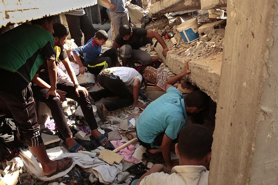 Men search for bodies of four missing people in a bombed building in Shati refugee camp after an Israeli airstrike on Aug. 4.