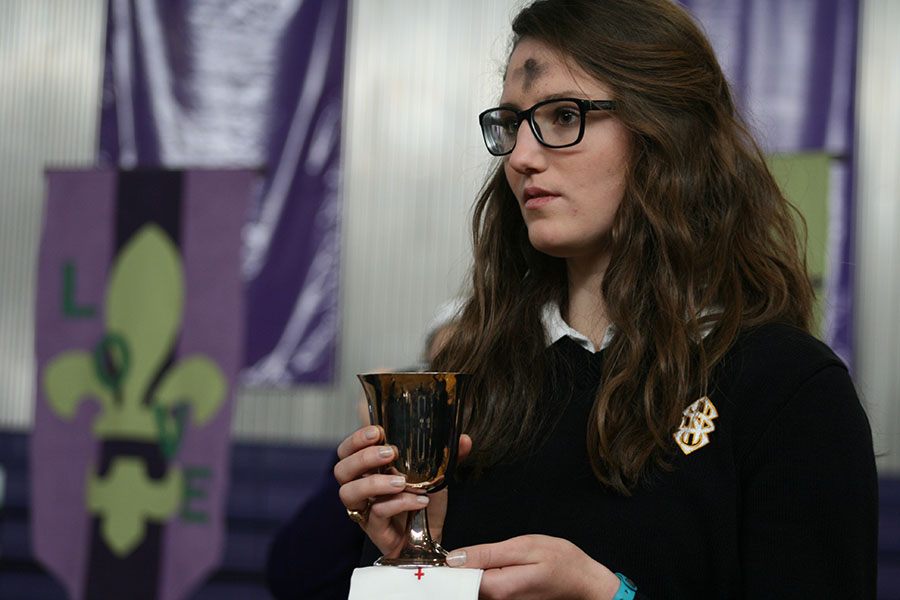 Senior Katherine Glaser stands ready to serve the Eucharist to her peers.