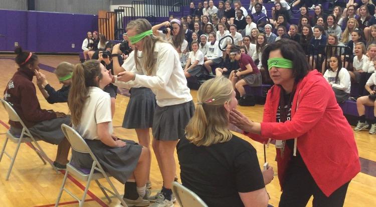 Spanish teacher Alicia Gómez gives math teacher Kristin Hilgenfeld a blind makeover, the purpose of the exercise was to emphasize, "no matter how much make up you wear, you're still beautiful." 