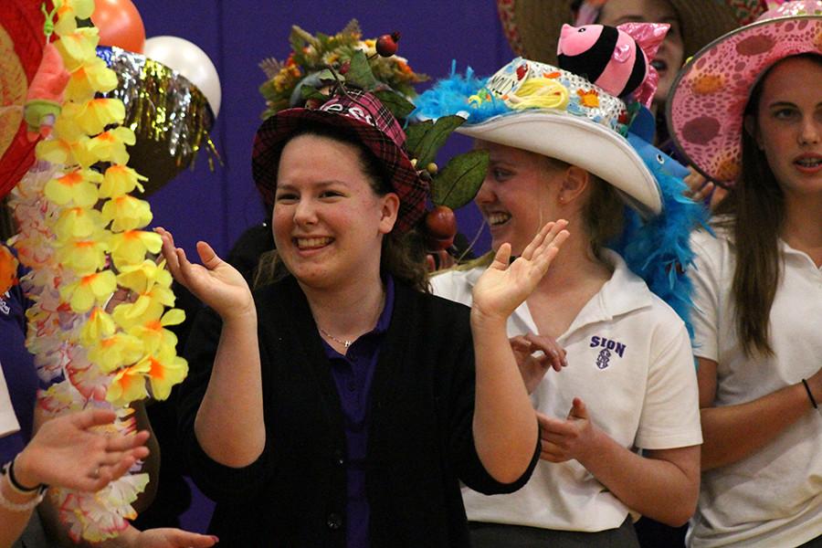 Freshman Tess Prusa sings the Senior Song after getting her beanie from seniors Elizabeth Burnham and Andi Swee.