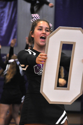 Sophomore Gabi Atchity helps form the word "storm" during the cheer team's pep assembly performance Sept. 4. 