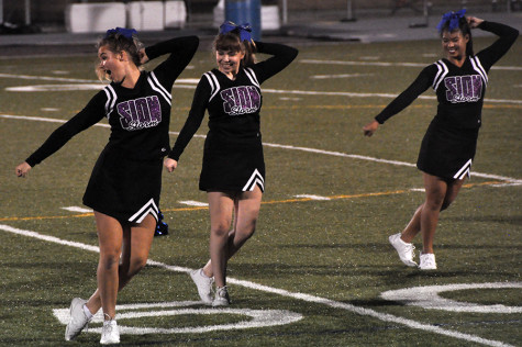 Seniors Emmie Gragg and Madison Masilionis and sophomore Courtney Hiatt perform during the cheer team's routine at Rockhurst High School Sept. 4. 