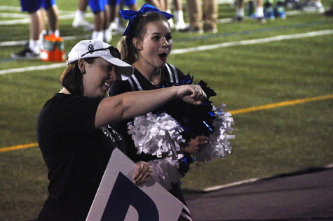 Sophomore Caroline Bono gasps as Cheer Coach Lisa Lauck does the "Whip" shortly before the cheer team's performance at Rockhurst High School Sept. 4. 