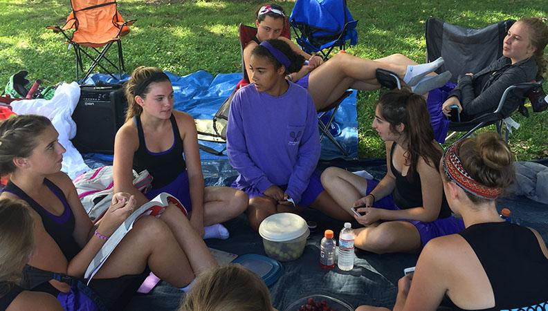 Senior Tess Pereira, freshman Keali Myrick and sophomores Lauren Graves, Meghan Frerking, Anna Tomka, Loulya Alabed and Meg Travis relax in the shade during the Sion JV Tournament.