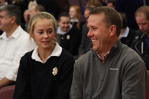 Senior Sarah King and father Bruce King talk before mass starts.