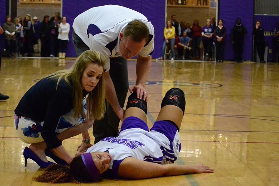 Varsity Head Coach Leslie Young and Athletic Trainer Kyle Jensen attend to sophomore Amaya Adams when she tore her meniscus during the last quarter of the Sion v. St. Teresa's game Jan. 29. 