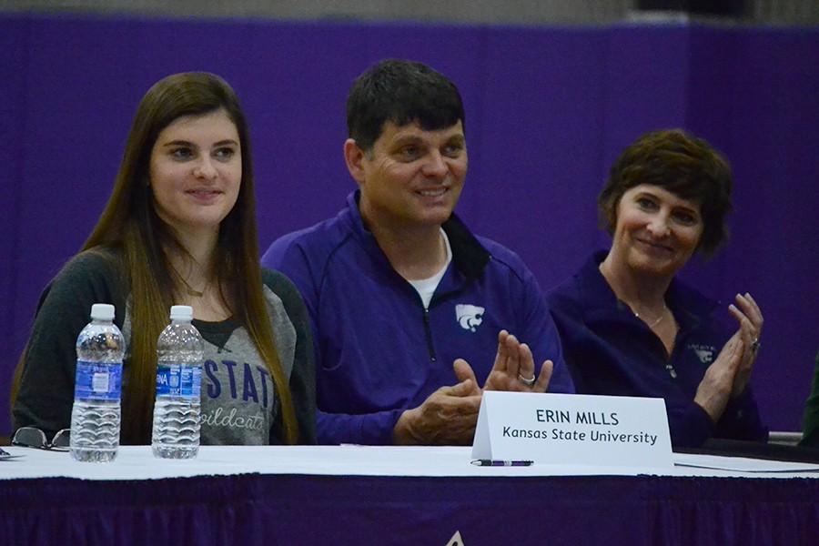 Senior Erin Mills and her parents, Todd and Anne Mills, listen to swim and dive coach Kelly Timson speak about Erin's time on the swim team. 