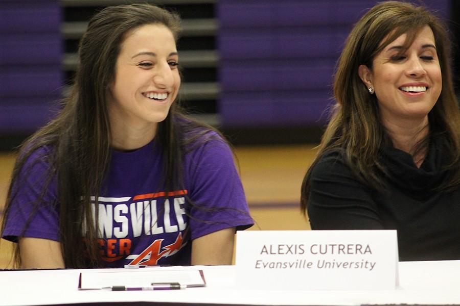 Senior Alexis Cutrera and her mother, Maria Cutrera, listen as Varsity Soccer Coach Matt Darby talks about Alexis' actions on the soccer field. 