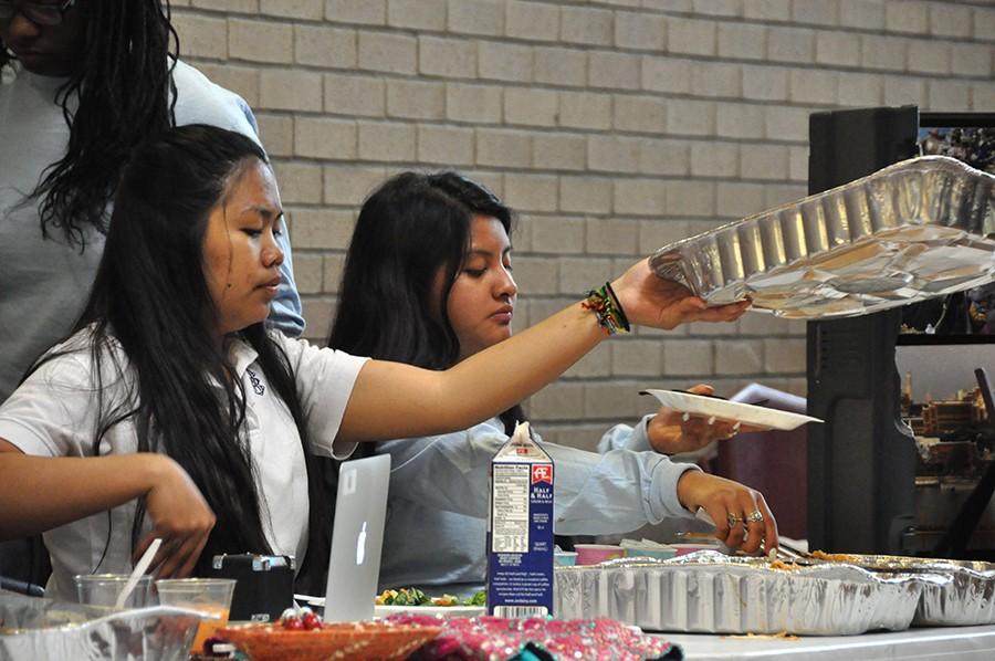 Seniors Aree Tomes and Lisbeth Juarez-Lopez serve Thai iced tea and pad thai at the Students Exploring and Educating Diversity club luncheon March 30. 