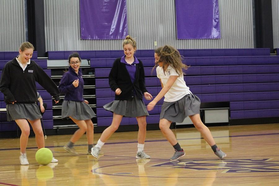 Sophomores Ellie Magsamen, Anna O'Byrne and Mary Evans protect the ball from junior Marie Orrick during the soccer activity at the pep assembly at April 11. 