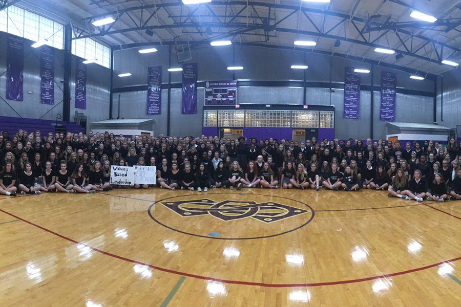 Students gather early in the gym Wednesday morning to take a picture in their black shirts to show their solidarity with the victim.