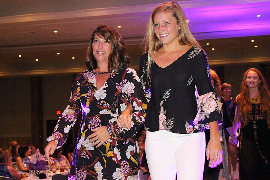 Senior Christy Kentfield and her mother Amy head out arm in arm for the final walk down the runway.