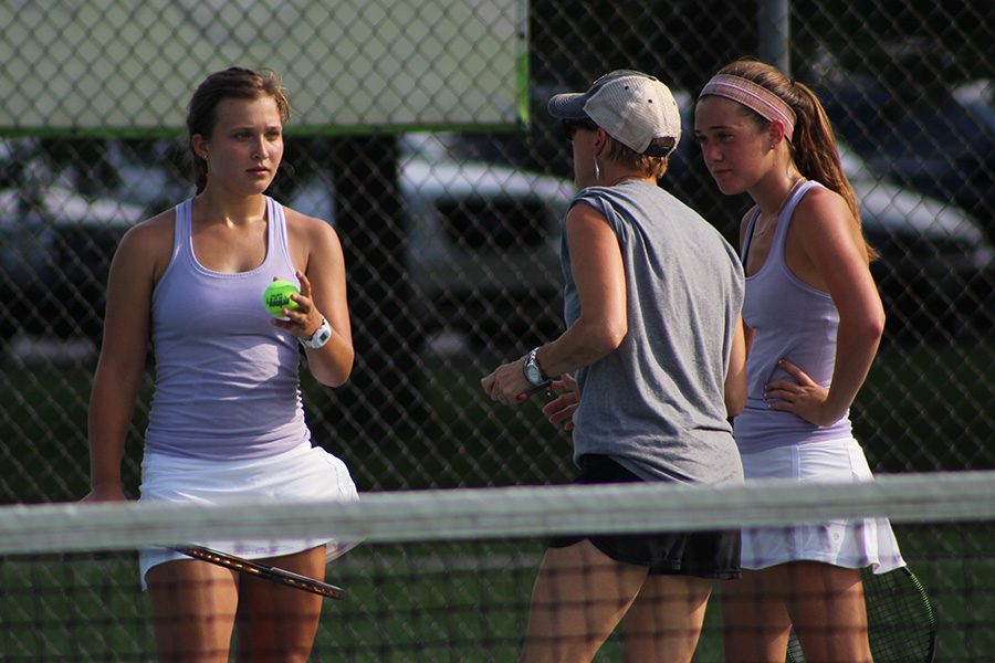 Assistant Coach Karen Phillips gives senior Zoé Trouvé and junior Lanie Jones some tips during their doubles match.