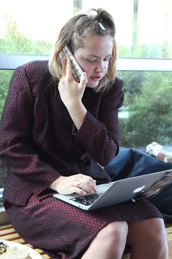 Senior Ali Odermann multitasks during study hall in her business themed clothing the fourth day of Spirit Week.