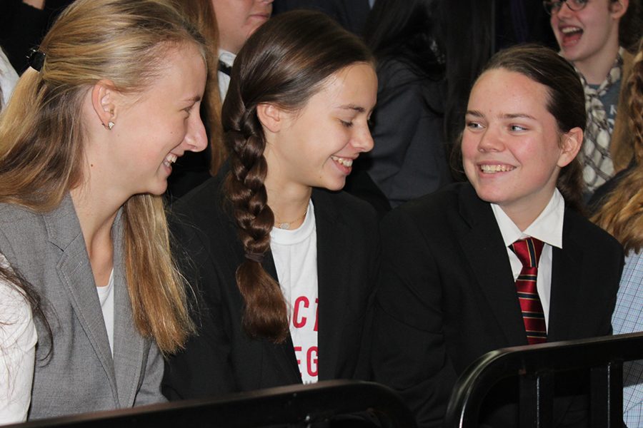 Sophomores Melissa Koppers, Megan Broomfield and Liz Oltjen talk to each other before the start of the Grande Assemble in their business outfits.