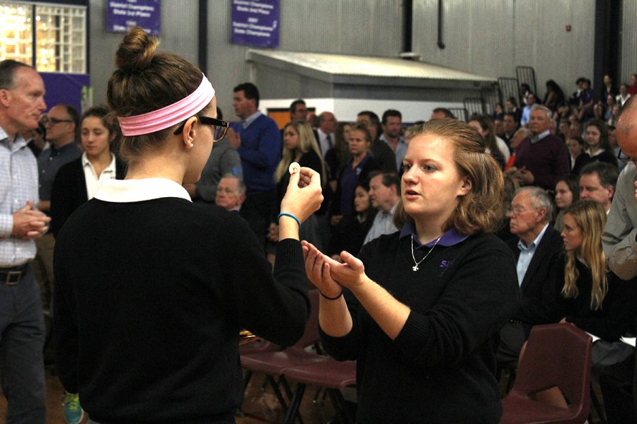 Junior Kaitlin Dervin receives the Eucharist from sophomore Libby Kramer.