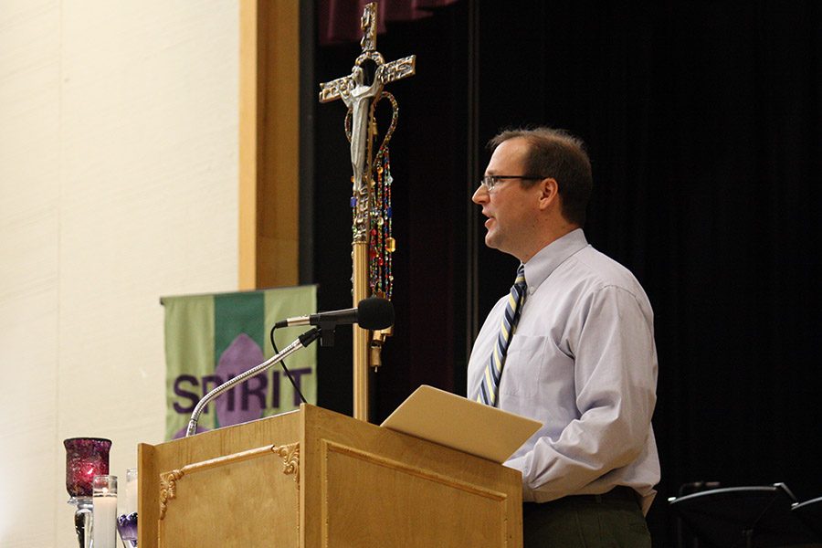 Religion teacher Paul Kramschuster reads a reflection after the Gospel.