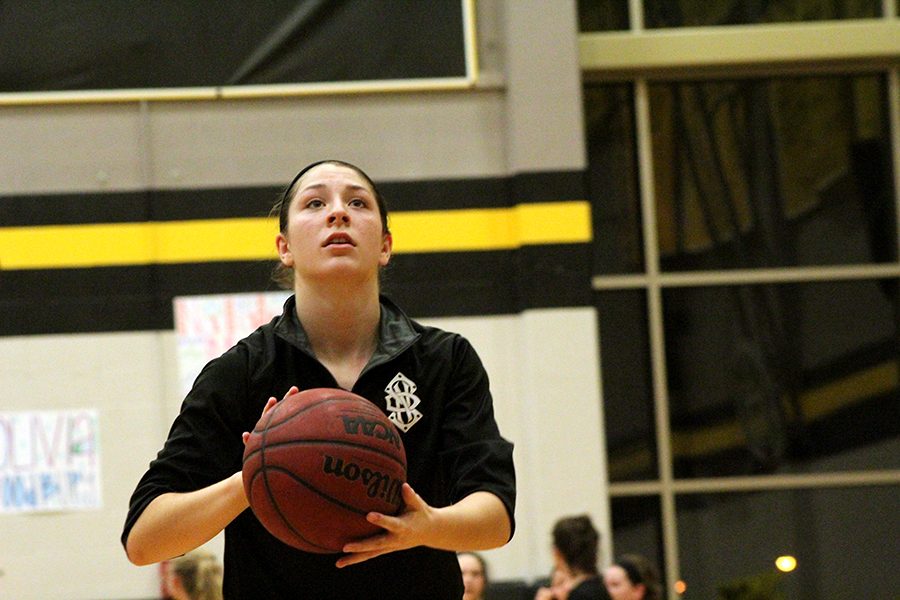 Junior Sarah Totta practices her shots before the start of the game.