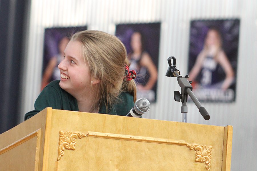 Senior Lauren Cordes watches a video about Children for Peace during her Senior Service Project presentation. Cordes was one of five seniors who presented their projects Feb. 9.