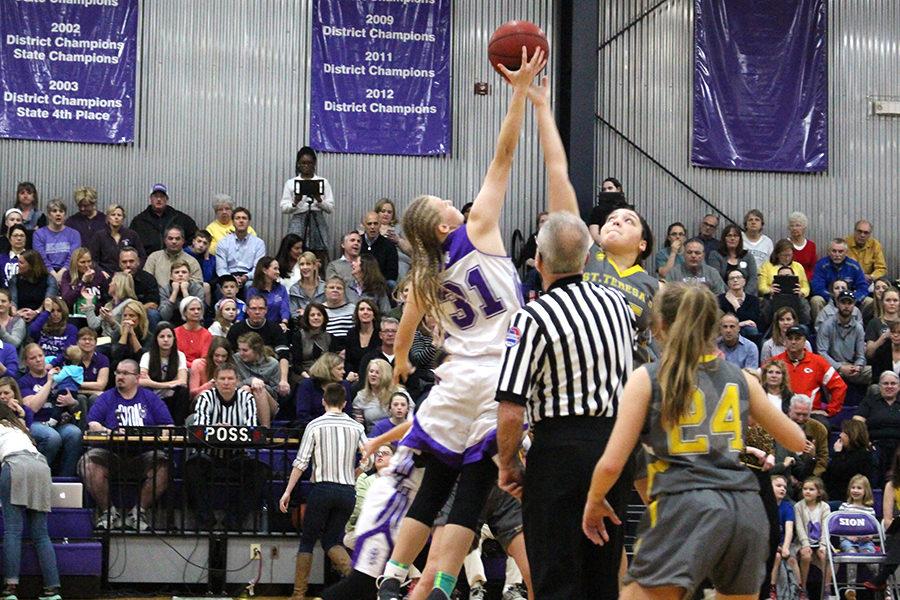 Junior Afton Fennewald reaches up for possession of the ball at tip-off.