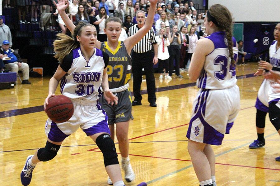 Freshman Anaiya Uhde dribbles down court with pressure from the opposing team.