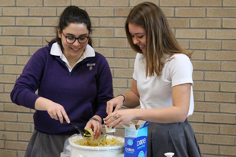 Senior Jessica Nicolosi helps senior Caitlyn Swope prepare a carrot and potato vegan Indian curry.