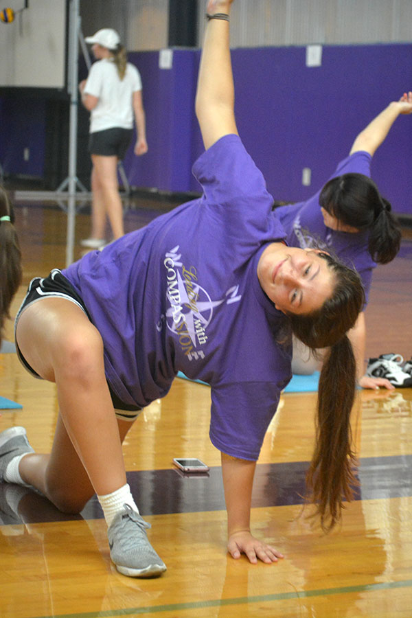 Senior Sarah Totta smiles while holding a yoga pose.