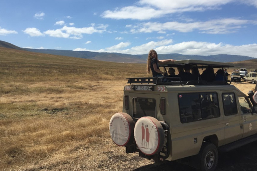  Senior Livy Wood sits atop a safari vehicle in the Ngorongoro Crater.