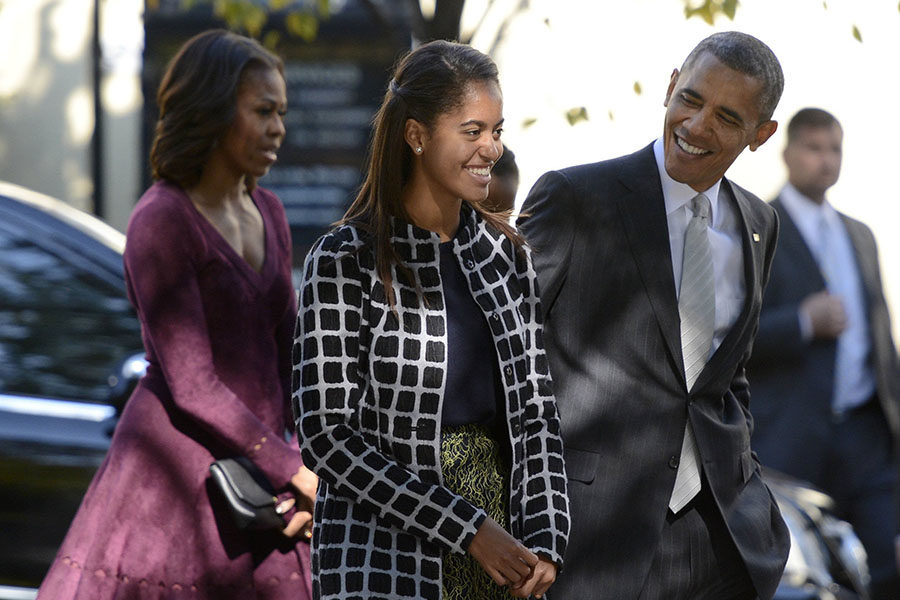 President Barack Obama talks with his daughter Malia, center, as the first family walks from St John's Church.