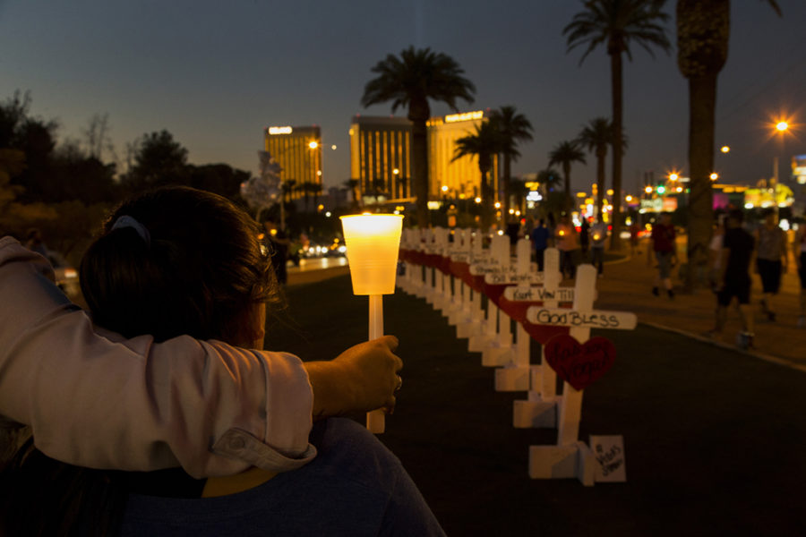 With wooden crosses bearing the names of those killed in the mass shooting, community members gather with candles to pay tribute to their loss on the median off Las Vegas Boulevard on October 5, 2017  in Las Vegas, Nevada. Mandalay Bay is in the background. Greg Zanis of Illinois drove all night to deliver the homemade crosses. (Gina Ferazzi / Los Angeles Times/TNS)