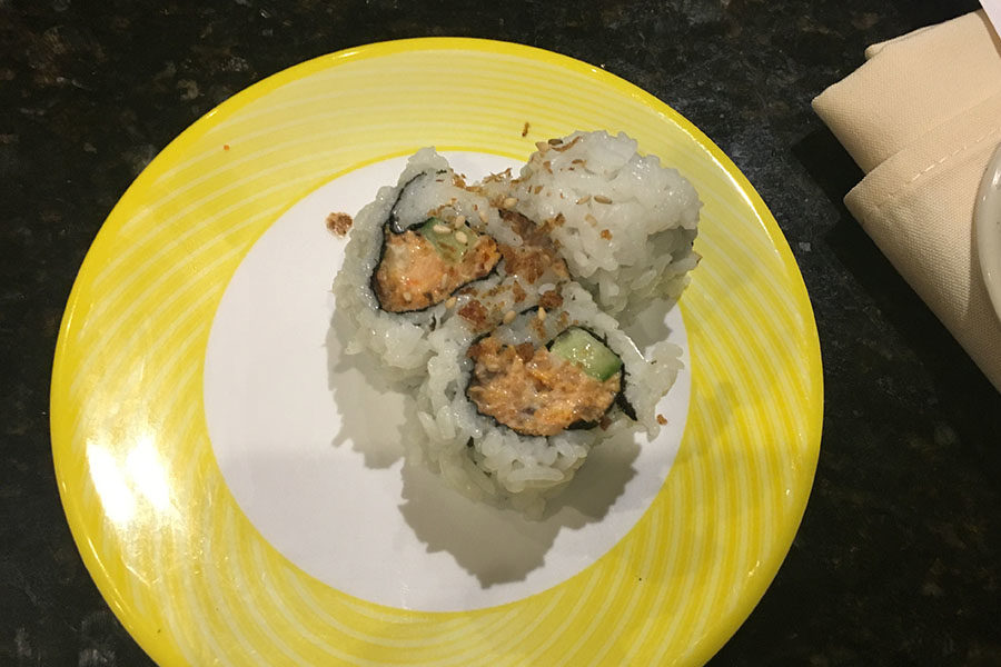 Pictured is half of a sushi roll with tuna and cucumber wrapped in seaweed paper, then coated in rice.