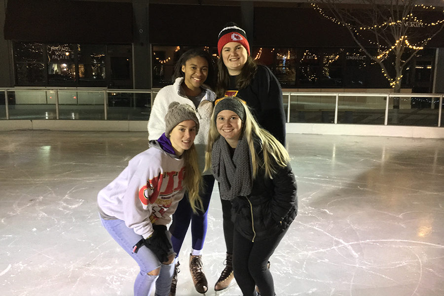 Junior Kaitlin Jones and seniors Phylicia Barner-Lewis, Kelly Nugent and Anna Tomka pose for a picture on the ice skating rink at Park Place. 