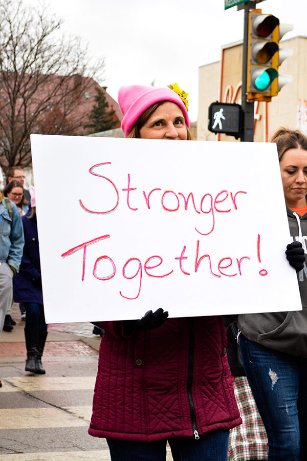 Walking down Massachusetts Street a women holds a sign in front of her at the Women’s March in Lawrence, Kansas Jan. 20, 2018.