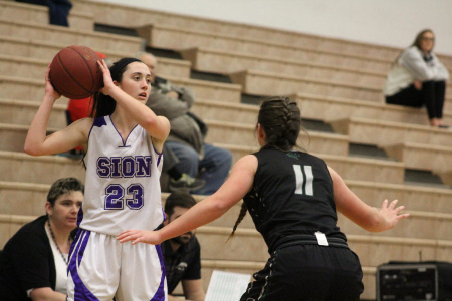 Senior guard Meghan Frerking aims to pass the ball over Staley senior Lindsey Gilbert. Sion went on to defeat Staley at the Blue Valley North varsity basketball tournament 45-33 Friday, Jan 19. 